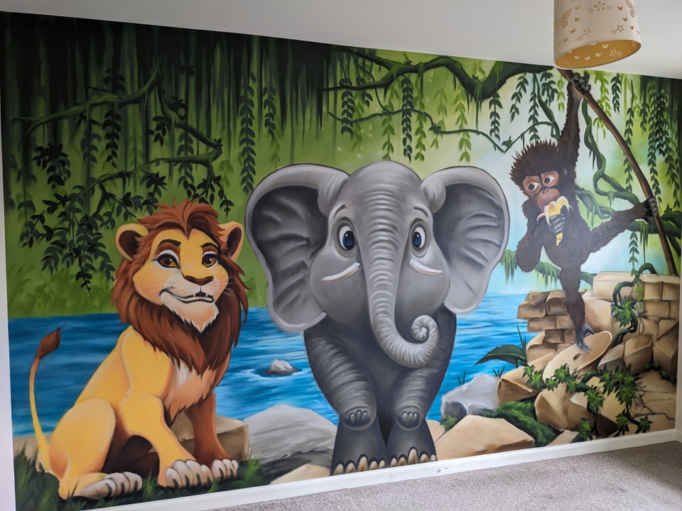 Vibrant jungle-themed children bedroom wall mural featuring a cartoon lion, a large elephant, and a monkey eating a banana hanging from vines above a blue river.